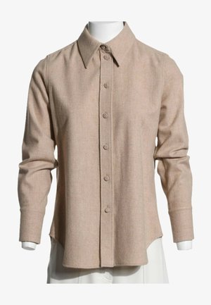 Langærmet beige skjorte med knapper og spids krave vist på en hvid mannequin krop.