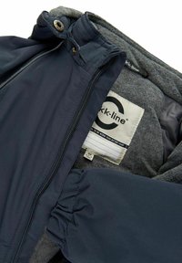 Marinblå jacka med grå fleecefoder, utrustad med frontdragkedja, tryckknappar och märkesskylt inuti. Texturerat tyg med rynkade ärmslut.