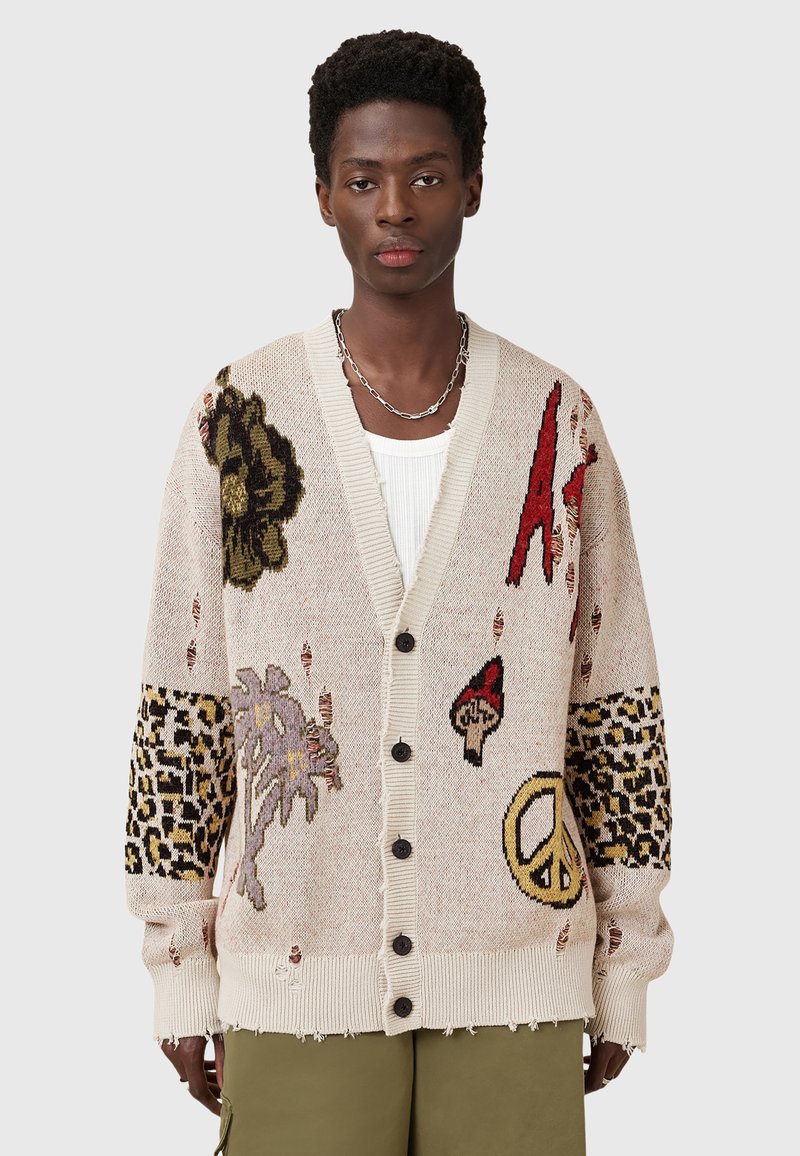 Knit cardigan in beige with textured patterns. Features colorful embroidered motifs, including leopard print and nature designs, and black buttons.