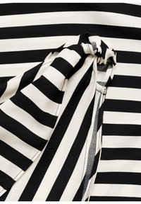 Mustavalkoraidallinen kangas, jossa solmittu korostus sivulla. Rakenne on sileä, ja siinä on vuorottelevia paksuja ja ohuita raitoja.