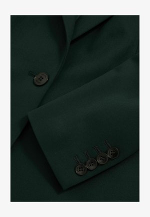 Blazer vert foncé avec un tissu lisse, revers en pointe et cinq boutons au niveau des poignets avec des boutons noirs.
