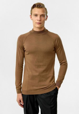Bruine gebreide trui met een hoge halslijn, geribbelde manchetten en zoom. Heeft een gladde textuur en een getailleerd ontwerp met raglanmouwen.
