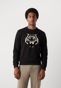 Schwarzer Sweatshirt mit einem detaillierten Tiger-Graphic in Creme und Braun auf der Vorderseite, mit rundem Halsausschnitt und gerippten Bündchen.