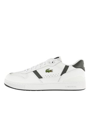 Zapatilla blanca de caña baja con detalles en negro, diseño con cordones, perforaciones cerca del logo y emblema de cocodrilo verde de Lacoste en el lateral.