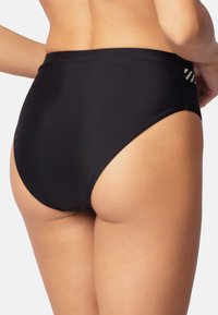 Hög midja svart bikiniunderdel gjord av slät tyg, med ett randigt accent vid sidan. Mjuk struktur och åtsittande design.