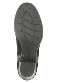 Musta kenkäsole, jossa on teksturoitu kuvio, hopeinen korkoakseli ja "Clarks"-brändinimi kohokuvioituna koron alueella.