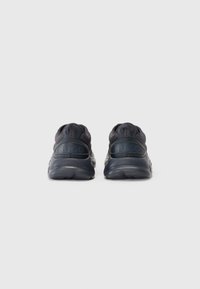 Navy sneakers with a textured fabric upper, rubber sole, and embossed "HUGO" logo on the heel. Rounded design with padded collar.