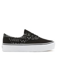 Black canvas sneaker with white rubber sole, featuring a textured black and grey Vans logo pattern along the upper. Rounded toe design.