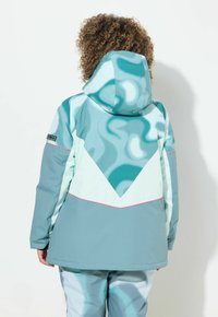 Tyrkysová a světle aqua bunda s geometrickým vzorem a kapucí. Má kontrastní růžové akcenty a hladký, vodoodpudivý materiál.