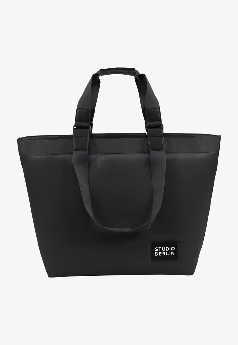 Borsa tote nera realizzata in tessuto resistente. Presenta due manici superiori, una forma rettangolare e una patch con il logo "STUDIO BERLIN" in testo bianco.