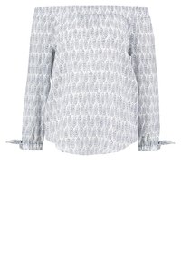 Blusa off-the-shoulder bianca con un motivo di foglie blu navy. Caratterizzata da maniche lunghe con polsini arricciati e fiocchi ai polsi.
