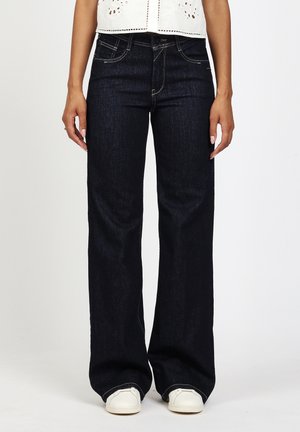 Dark blue denim jeans with a relaxed fit, straight leg design, featuring classic five-pocket styling and contrasting stitching details.
