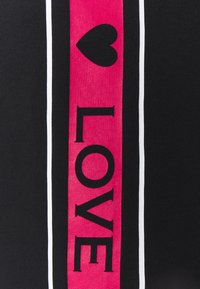 Tela negra con rayas verticales rosas bordeadas por finas líneas blancas, que presenta un corazón negro y la palabra "AMOR" en letras negritas.