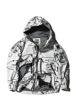 Valge jakk mustade graafiliste mustritega. Omab kapuutsi, tõmblukuga taskuid ning on valmistatud kergest veekindlast materjalist.