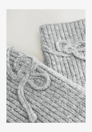 Accesorios de punto grises con una textura acanalada. Incluye detalles de hilo suave anudados para el cierre, mostrando calidez y un aspecto acogedor.