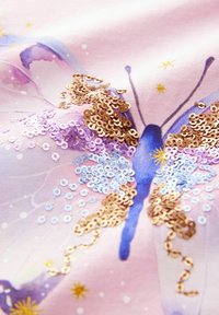 Diseño de mariposas en tela rosa, adornado con lentejuelas doradas, azules y lavandas. Presenta acentos de acuarela y motivos de estrellas.
