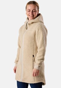 Fleece capuchonjack in crème, met een rits aan de voorkant, zijzakken en elastische manchetten. Getextureerde, zachte stof met een comfortabele pasvorm.