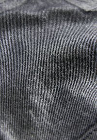 Textureret stof i nuancer af grå med lodrette striber. Materialet ser ud til at være vævet med en blød, let ru overflade.