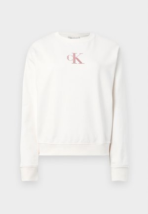 White cotton sweatshirt with crew neck and long sleeves. Features a pink embroidered "ck" logo on the chest and ribbed cuffs.