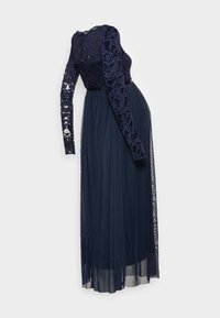 Mörkblå gravidklänning med långa spetsärmar, en figursydd spetsbyst och en flödande genomskinlig kjol, med en lätt släp bak.