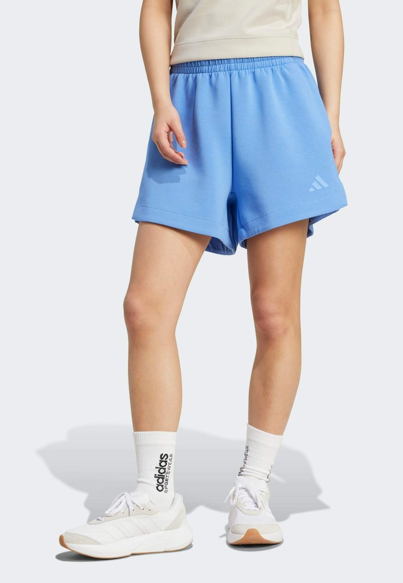 Modré sportovní šortky s elastickým pasem, vyrobené z měkkého materiálu. Mají ohrnutý lem a malé bílé logo Adidas na boku.