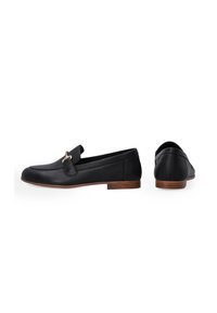 Schwarze Leder_SLipper mit flacher Holzsohle, ausgestattet mit einem dekorativen Riemen und Hardwaredetails. Schlichtes, abgerundetes Design und glatte Textur.