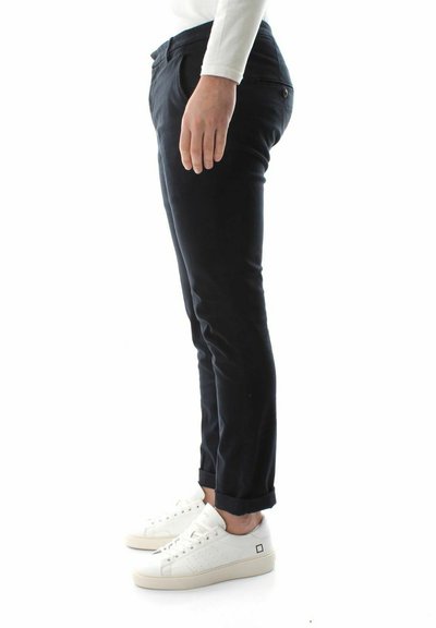 Sorte skræddersyede bukser med slim fit, præget af opfoldede bukseender, frontlommer og båret med hvide sneakers. Glat stofstruktur.