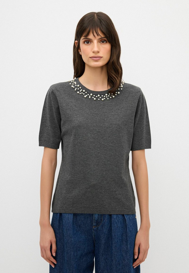 Tmavě šedé tričko s krátkým rukávem a kulatým výstřihem, zdobené několika bílými korálky kolem límce. Měkká, texturovaná tkanina.
