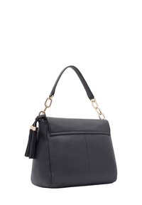 Zwarte leren handtas met een gestructureerde vorm, met een handvat van gouden metaalketting en een kwastje aan de zijkant.