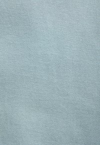 Lichtblauw textiel met een gladde, gelijkmatige structuur en diagonale ribbelpatroon. De stof lijkt zacht en geschikt voor verschillende toepassingen.