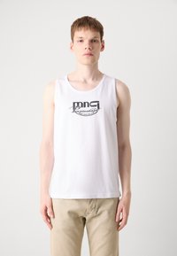 Witte katoenen tanktop met een zwart grafisch logo op de voorkant. De stof lijkt glad en lichtgewicht, met een ronde halslijn.