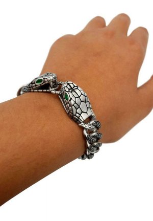 Bracciale a forma di serpente in argento con squame testurizzate e occhi con gemme verdi vivaci, che mette in mostra dettagli intricati e un design avvolto.