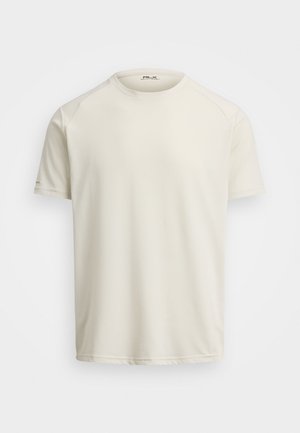 T-shirt à manches courtes couleur crème clair en tissu doux et respirant, avec un col rond et des manches raglan. Design minimaliste, côtés sans couture.