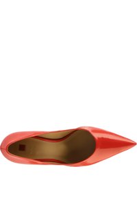 Coral patent leather pump with a pointed toe, smooth surface, low-cut sides, and beige interior highlighting logo detail.