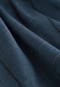 Vævet stof i mørk marineblå med en glat tekstur, der har subtile linjer og et let meleret udseende.