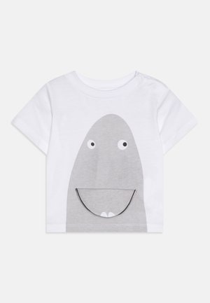 T-shirt bianca a maniche corte con un design di squalo grigio caratterizzato da grandi occhi e un sorriso. Realizzata in morbido cotone con chiusura a pressione sulla spalla.