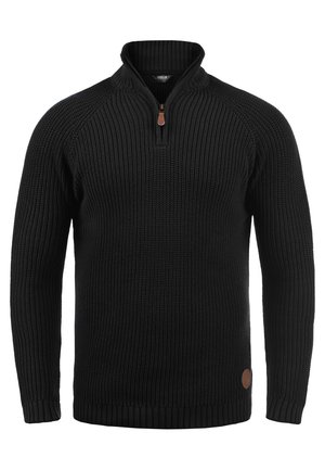 Pull en tricot noir avec un col montant et une fermeture éclair, présentant des poignets et un ourlet côtelés, un tissu texturé et un détail en cuir rond logo.
