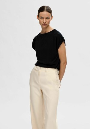 Zwart kort mouwtop met een ronde halslijn, gecombineerd met lichtbeige hoge taille broeken. Glad materiaal met een ontspannen pasvorm en een minimalistisch ontwerp.