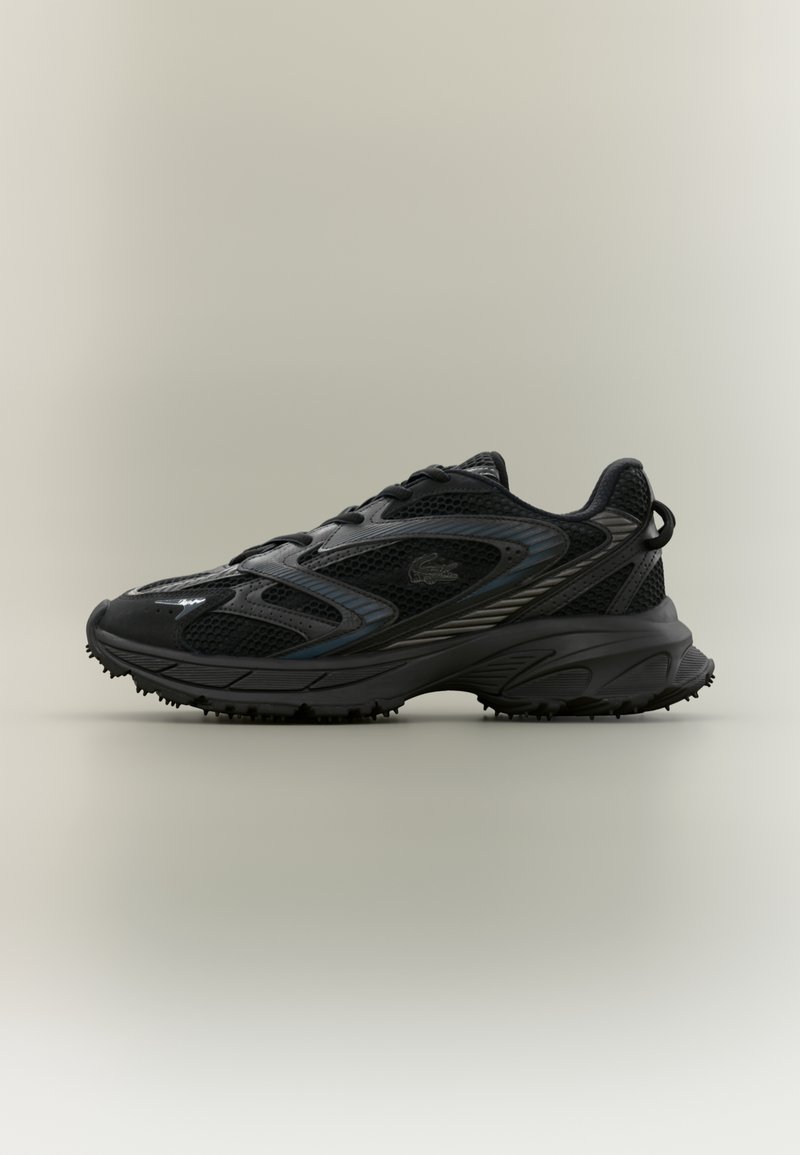Chaussure de course noire avec empiècements en mesh, semelle texturée et logo discret sur le côté, présentée sur un fond uni clair.