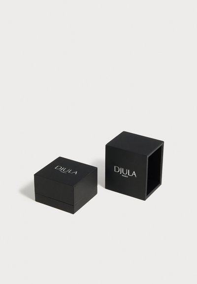 Deux boîtes à bijoux carrées noires avec logos argentés "DJULA PARIS", une fermée et une ouverte montrant l'intérieur vide.
