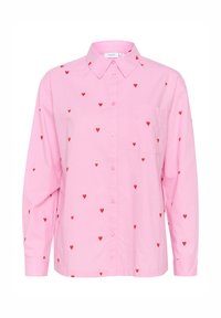 Camicia a maniche lunghe rosa chiaro con motivi a cuore rossi, chiusura con bottoni davanti e un taschino sul petto. Realizzata in tessuto di cotone.