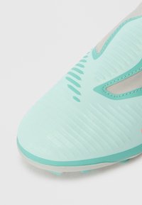 Svijetlo plavozeleni nogometni kopački s teksturiranom površinom i šivanim dizajnerskim detaljima, prikazani iz kuta prednjeg prsta na bijeloj pozadini.