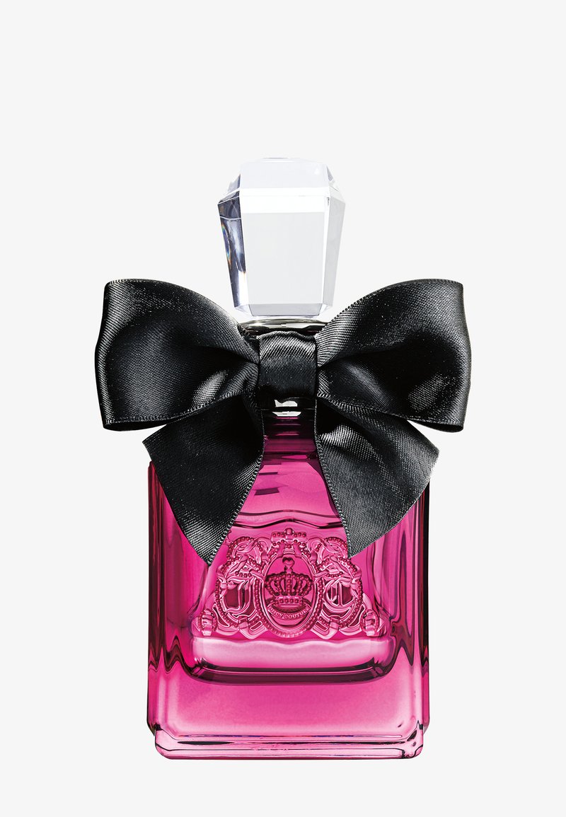 Flacon de parfum en verre rose avec un blason en relief, un grand nœud en satin noir et un bouchon transparent facetté sur un fond blanc uni.