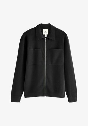 Sort zip-jakke lavet af tekstureret stof, med krave og to frontlommer. Enkel design med lige pasform og uden udsmykninger.