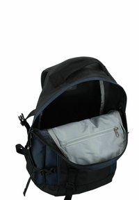 Svart och marinblå ryggsäck med ett toppflik, en öppen insida och ett ljusgrått zip-paket inuti. Justerbara remmar och texturera tyg.