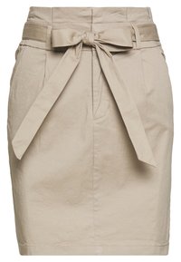 Jupe en coton beige avec une ceinture nouée, poches avant et une texture lisse. Présente une silhouette ajustée et une longueur au-dessus du genou.