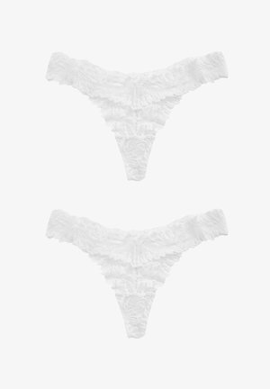 Perizoma bianco in pizzo con bordi arruffati e un motivo floreale, dotato di una cintura stretta e di un design posteriore triangolare.