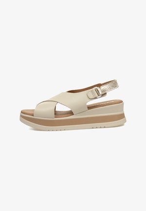 Sandalias de plataforma de cuero color crema con un diseño de cintas cruzadas, correa en el tobillo ajustable, acentos en marrón y un detalle texturizado en dorado.