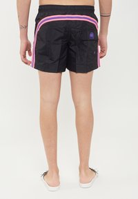 Costumini da bagno neri con strisce laterali rosa e viola, vita elasticizzata e tasca cargo. Realizzati in materiale liscio e leggero.