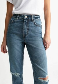 Hoge taille blauwe denim jeans met een licht verouderd ontwerp, voorzien van versleten kniezakken en de klassieke vijf-pocket stijl.